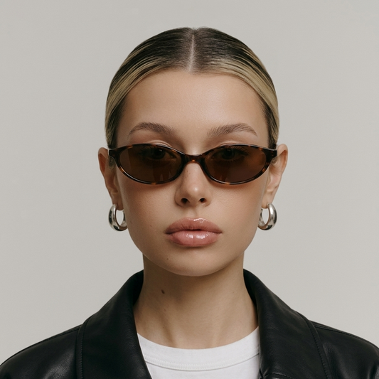 Person wearing sunglasses and a black leather jacket on a plain background